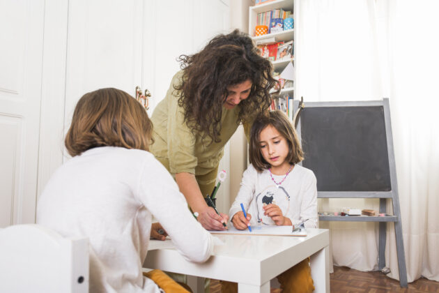 mother helping daughters with drawings